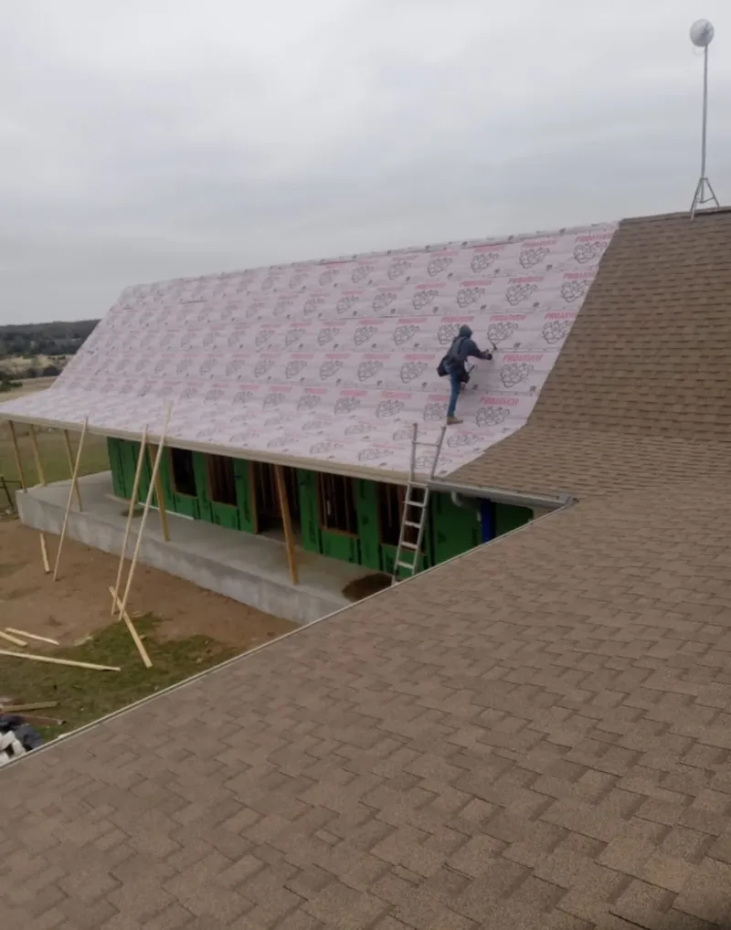 Worker preparing underlayment for a metal roof installation in Alsip